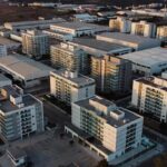 Vista aérea de edifícios multifamiliares e galpões industriais no Brasil para análise de NOI estabilizado.