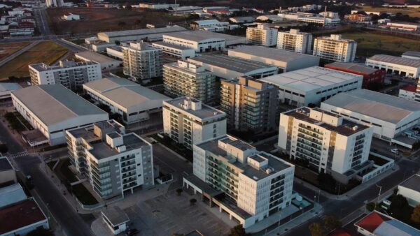 Vista aérea de edifícios multifamiliares e galpões industriais no Brasil para análise de NOI estabilizado.