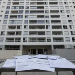 Edifício residencial em São Paulo com documentos de análise financeira de cap rate e IPTU