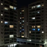Edifícios residenciais em São Paulo com janelas iluminadas representando taxa de ocupação