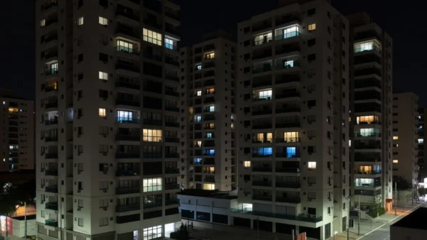 Edifícios residenciais em São Paulo com janelas iluminadas representando taxa de ocupação