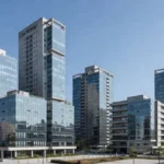 Edifícios modernos em São Paulo representando holdings imobiliárias e análise de IR sobre locação e venda de ativos.