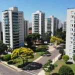 Bairro residencial brasileiro com benfeitorias públicas e edifícios, análise de valorização imobiliária